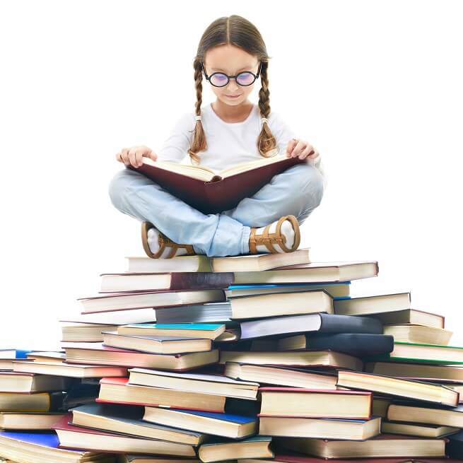 たくさんの本の上に座る少女