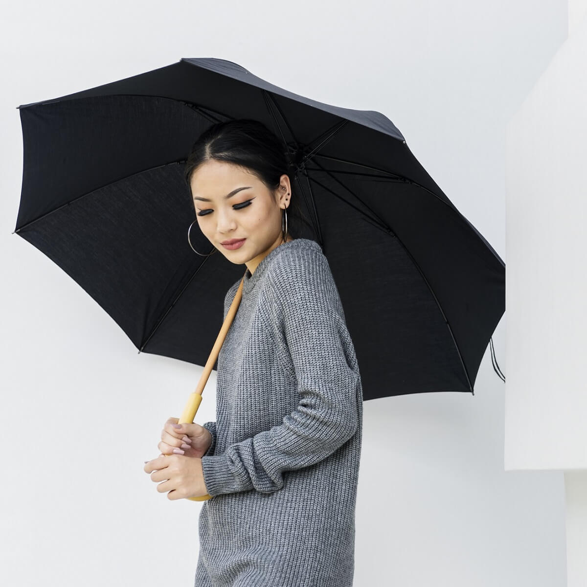黒の傘をさす女性。